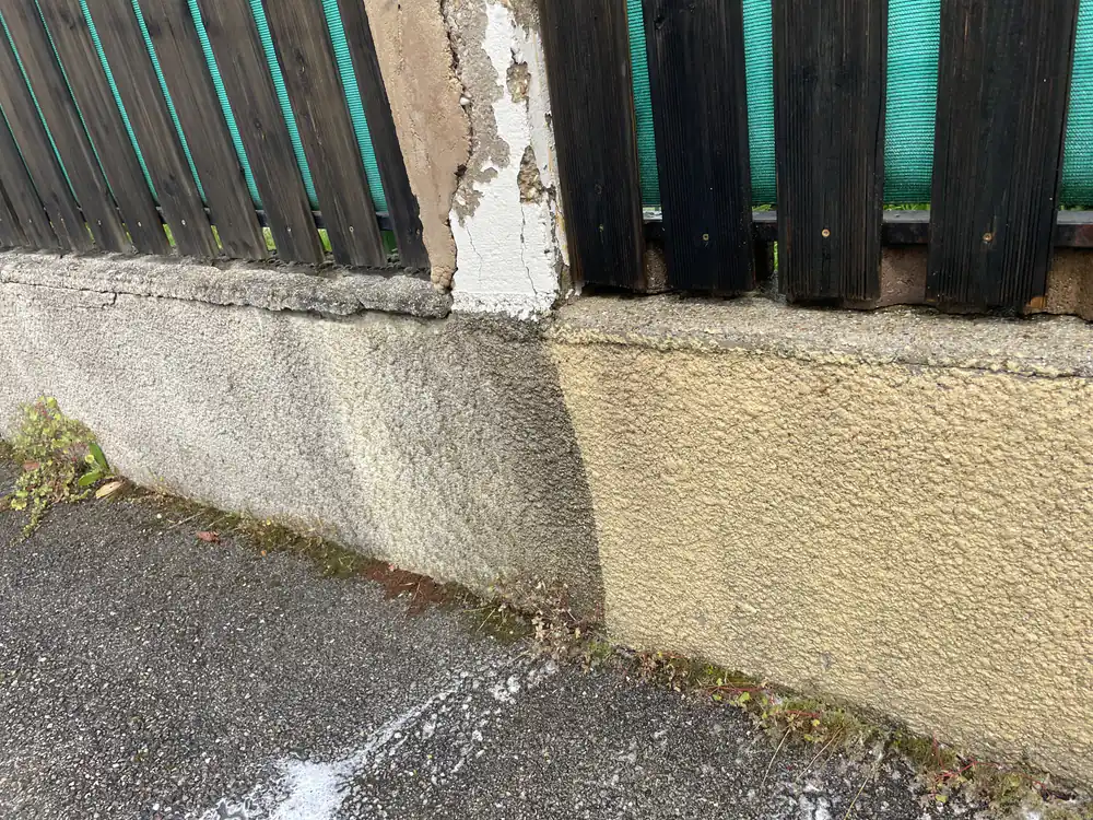 Soubassement de mur nettoyé sur la moitié droite, contraste visible