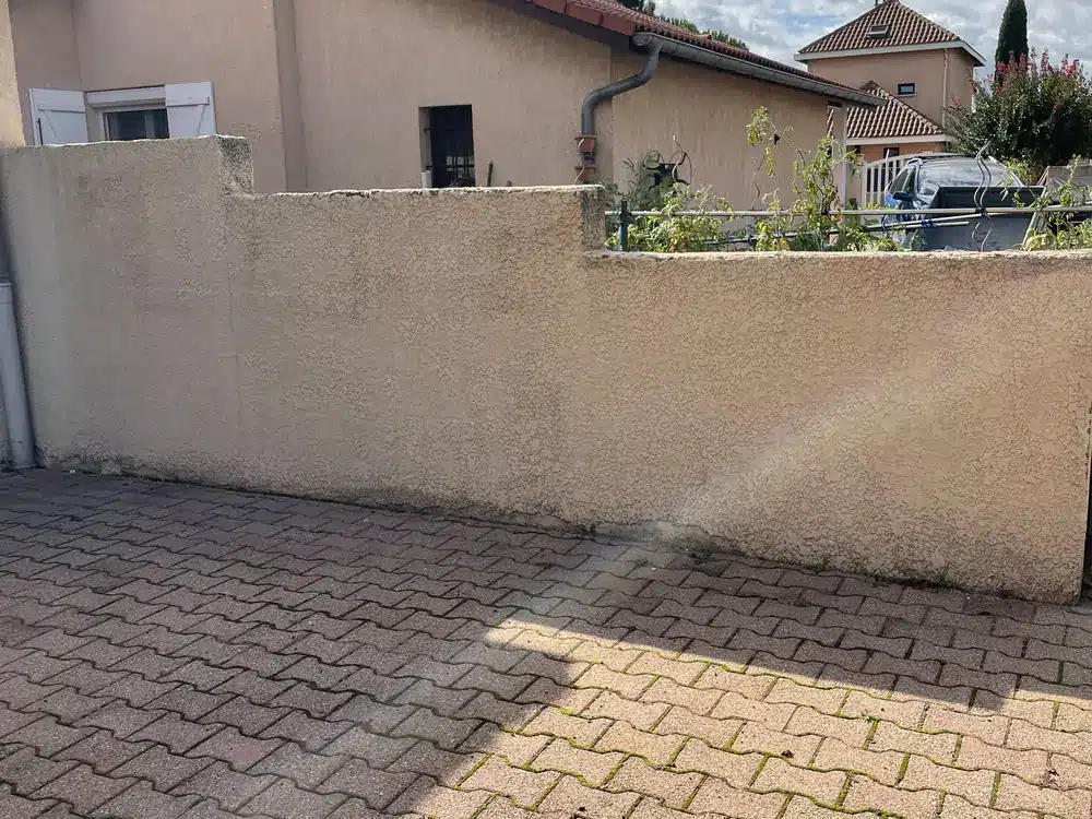 Mur de clôture et pavés nettoyés et démoussés