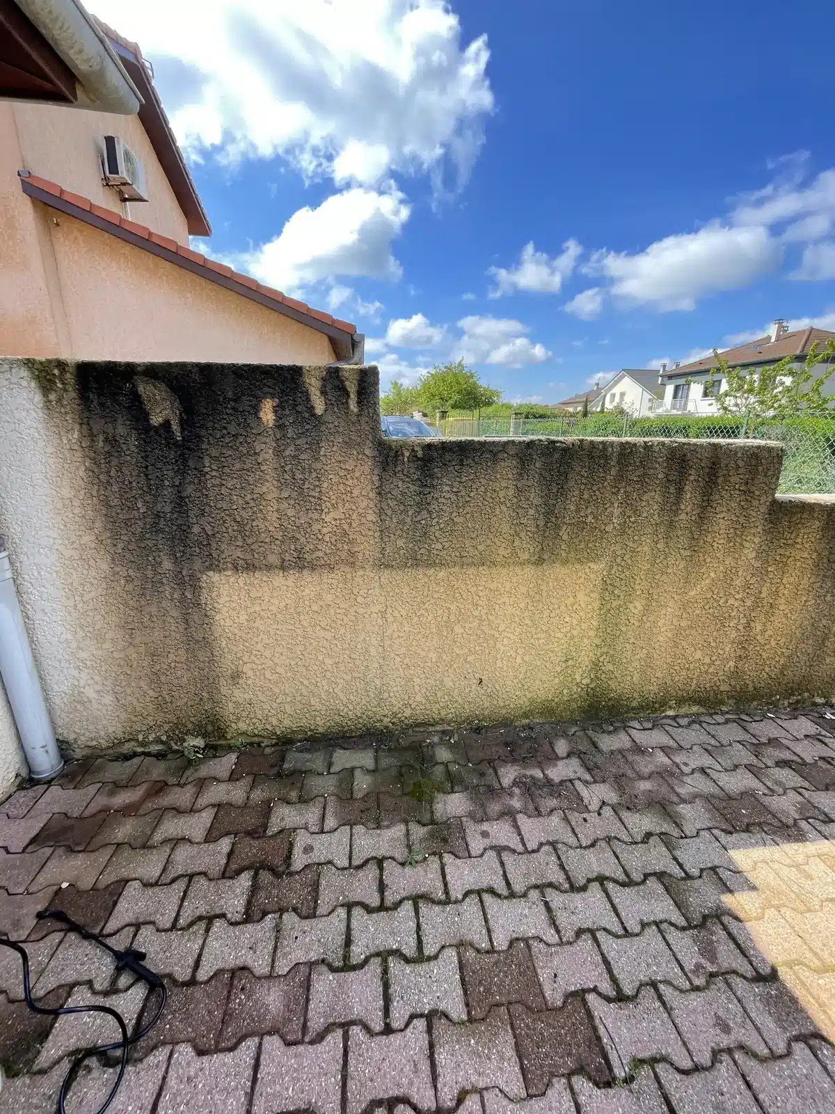 Mur et pavés encrassés avant le nettoyage